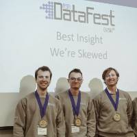 Four students awarded the Best Insight Award pose in front of the DataFest logo.